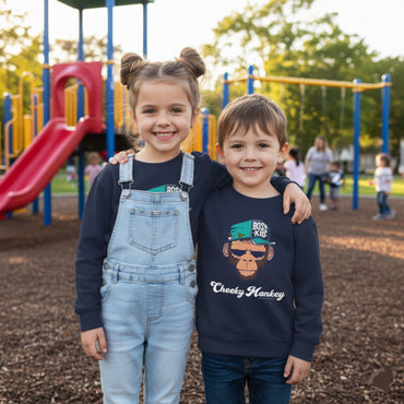 Two children standing on a playground with a colorful slide and equipment in the background.