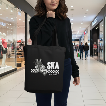 Person holding a black tote bag with 'Ska for Life' design on a white background