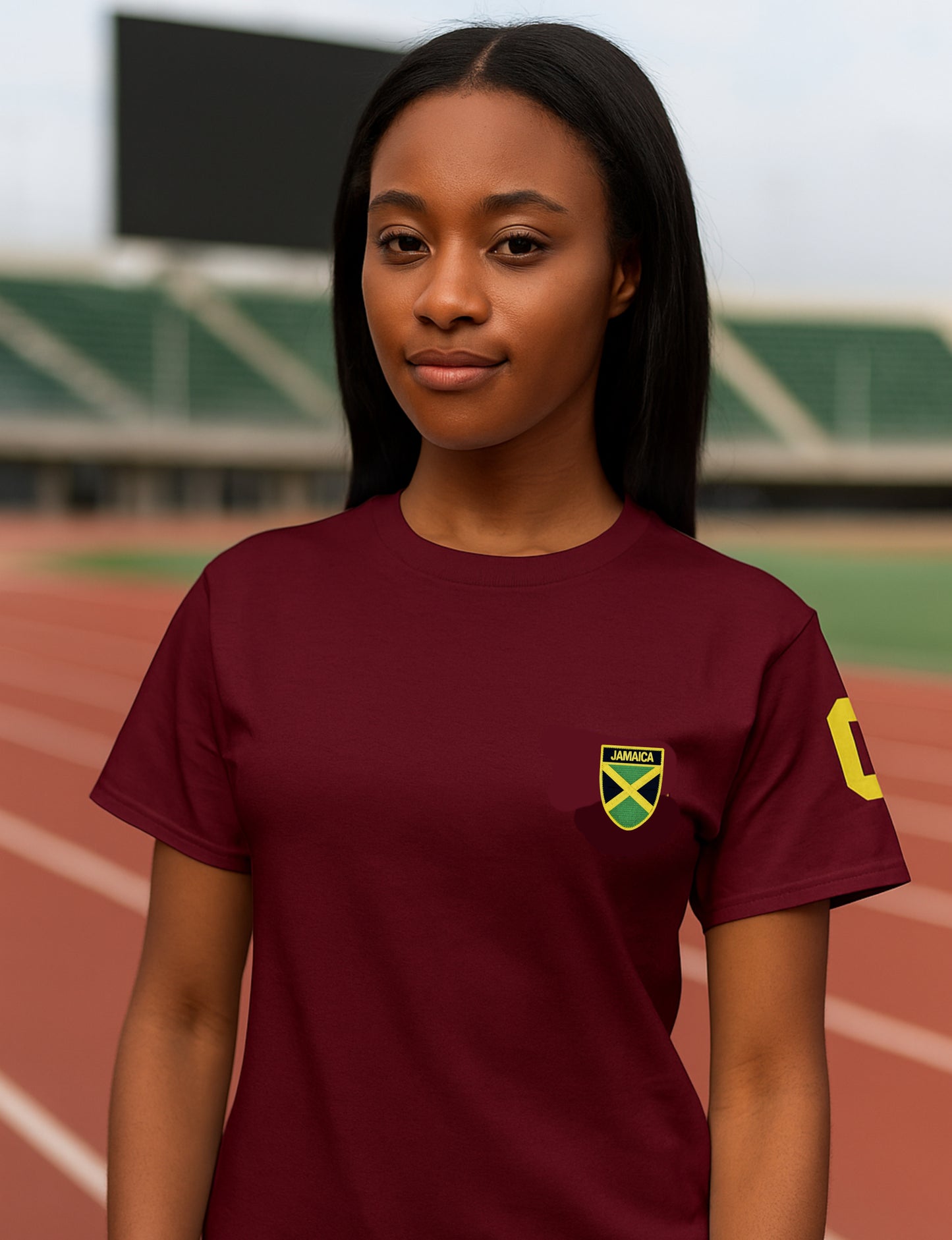 Person wearing a maroon t-shirt with a logo on a sports field