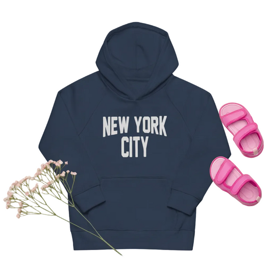 Navy hoodie with 'New York City' text, pink sandals, sunglasses, and flowers on a white background
