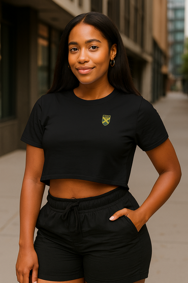 Woman wearing a black crop top with a logo and black shorts on a city street.