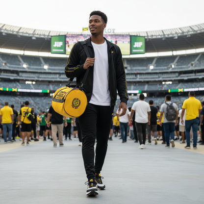 Man walking on a track with a yellow bag in an outdoor stadium.