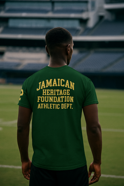 Person wearing a green t-shirt with 'Jamaican Heritage Foundation Athletic Dept.' text on a sports field.