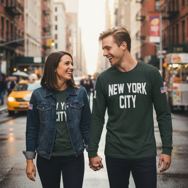 Two people walking down a city street wearing 'New York City' shirts.