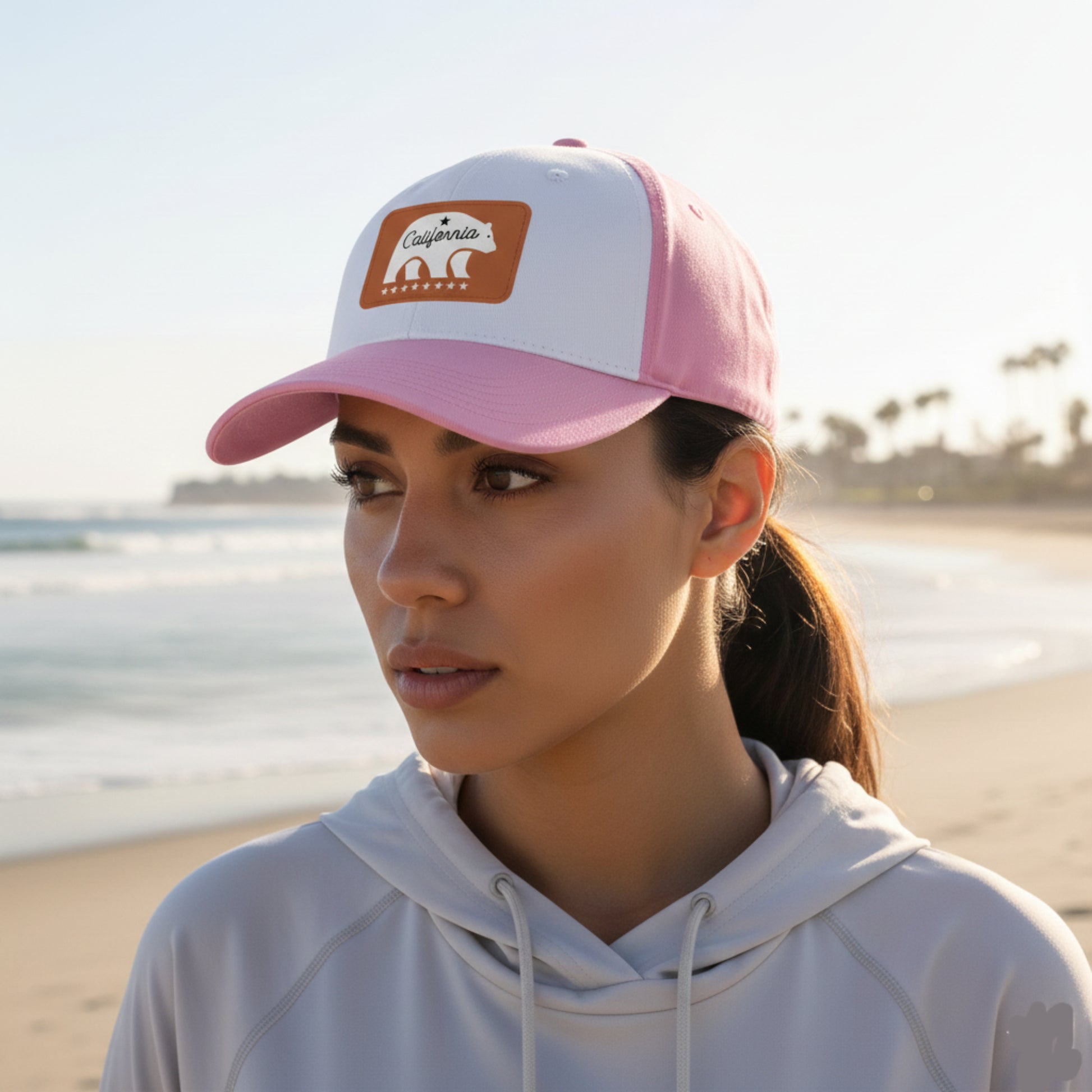 Woman wearing a pink and white cap with a logo on a beach