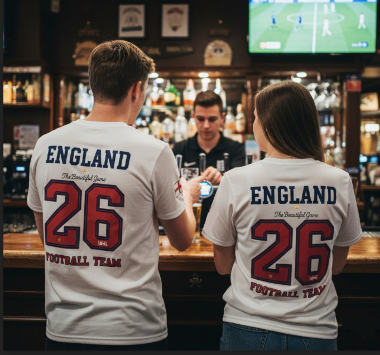 Two people wearing England football team t-shirts in a bar setting.
