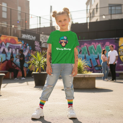 Child wearing a green t-shirt with a graphic design, standing in an urban setting with graffiti.