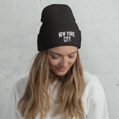 Woman wearing a black beanie with 'New York City' text against a light gray background