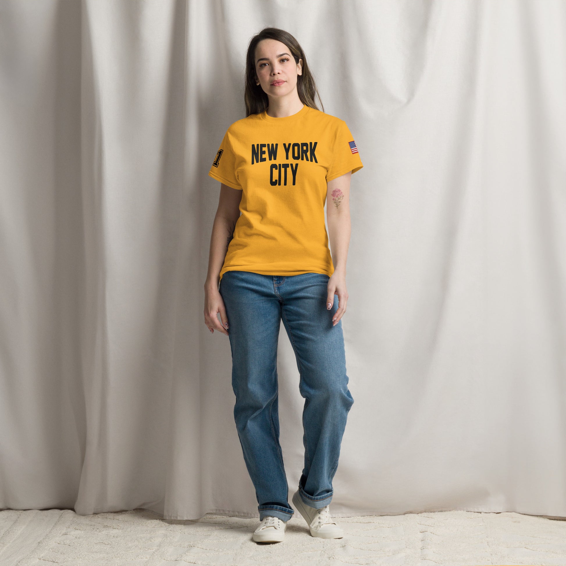 Person wearing a yellow 'New York City' t-shirt against a plain background