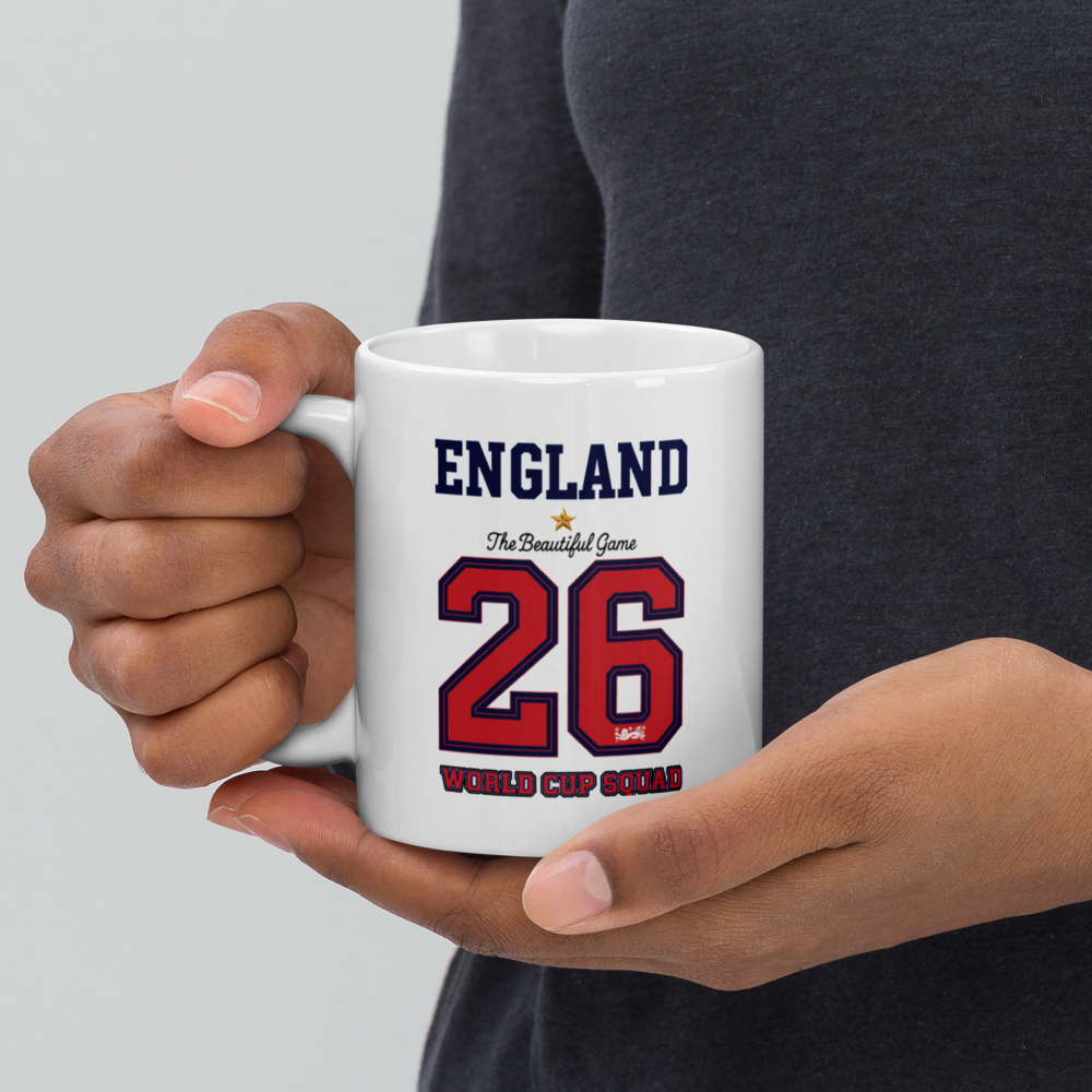 Person holding a white mug with 'England' and number '26' printed on it.